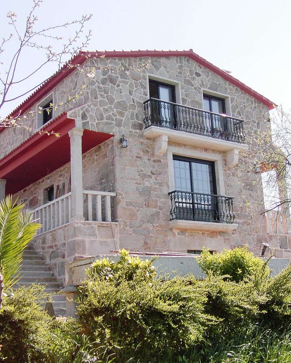 Casa de piedra de dos plantas con balcones y jardín en Barros, Pontevedra